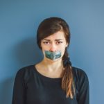 Woman with tape over mouth