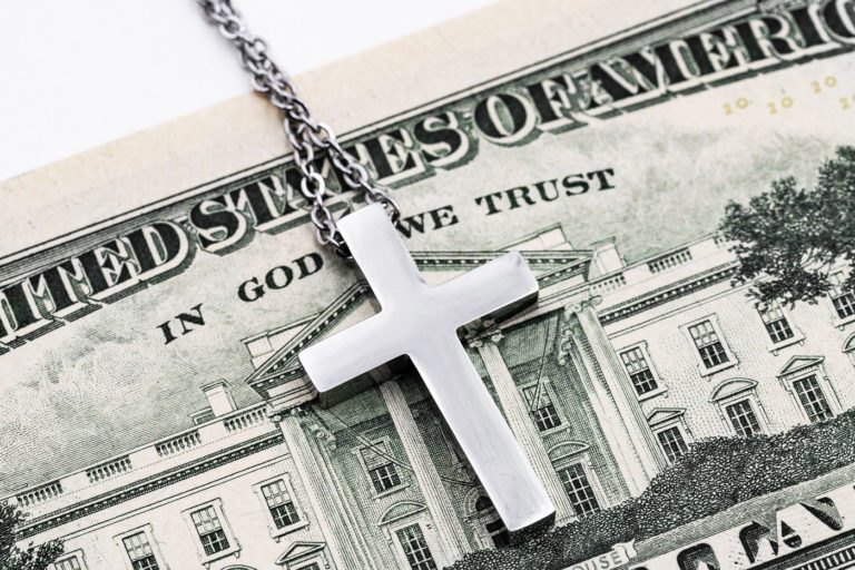 Cross on dollar bill reading "In God we trust"