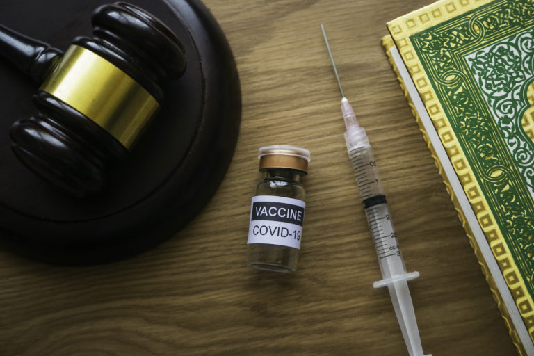 COVID-19 vaccine next to wooden gavel