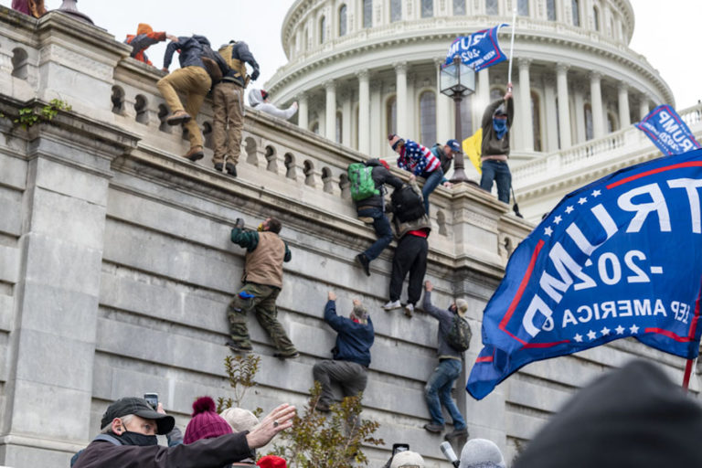 January 6th rioters climbing onto the Capitol Building