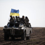 Ukranian soliders sitting on military vehicle
