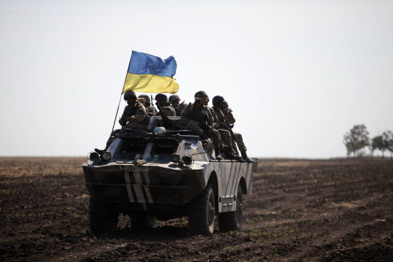 Ukranian soliders sitting on military vehicle