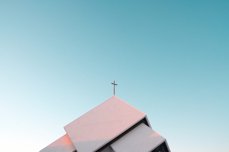 Photo of a church's roof with a cross on top