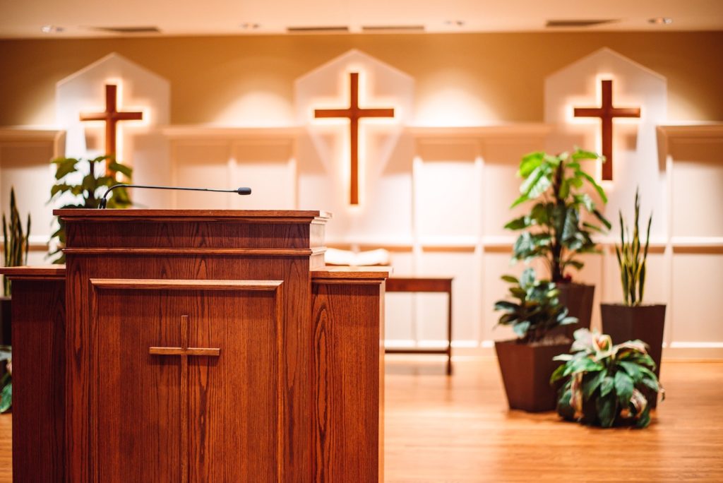 Photo of interior of a protestant church—pulpit with three crosses behind it