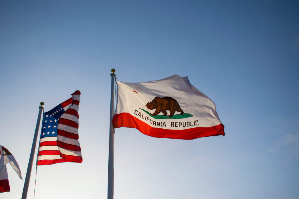 Photo of California Flag next to American flag