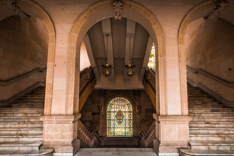 Photo of marble arches with twin stairways and stained glass