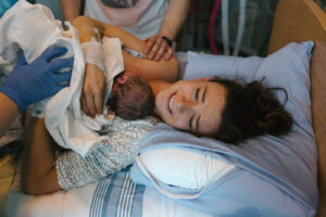 Brand new mother and child after delivery in hospital room