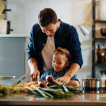 Father and daughter chopping vegetables