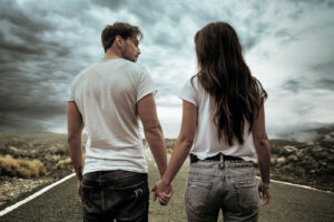 Two young hitchhikers walking along the road