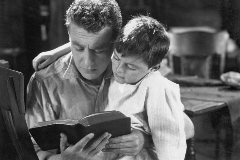 Portrait of dad reading bedtime story to son