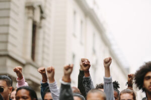 Arms raised in protest. Group of protestors fists raised up in the air.