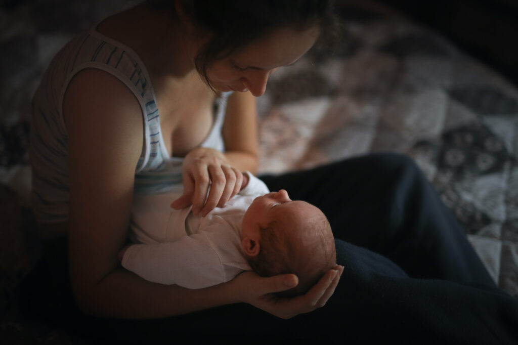 Sweet newborn baby next to the mother, the gentle communication, concept real interior, natural photo