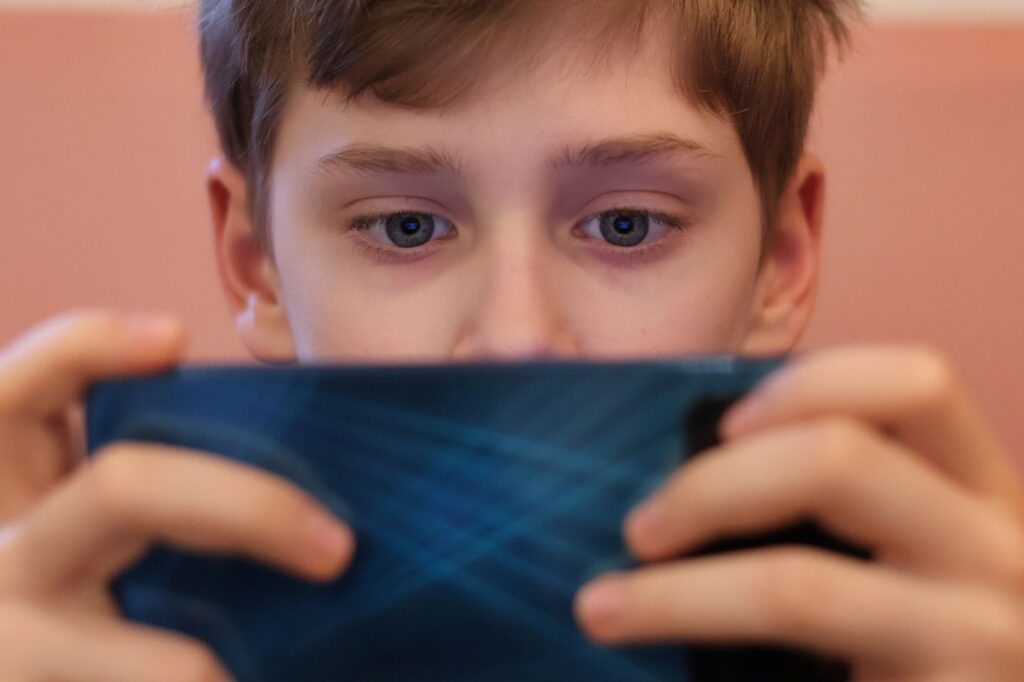 lonely kid staring lifelessly at a phone screen