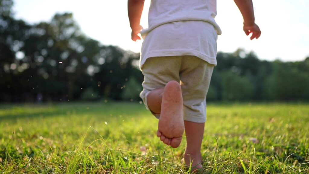 little boy running barefoot outside