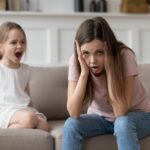 stressed out young mom with kid throwing a fit