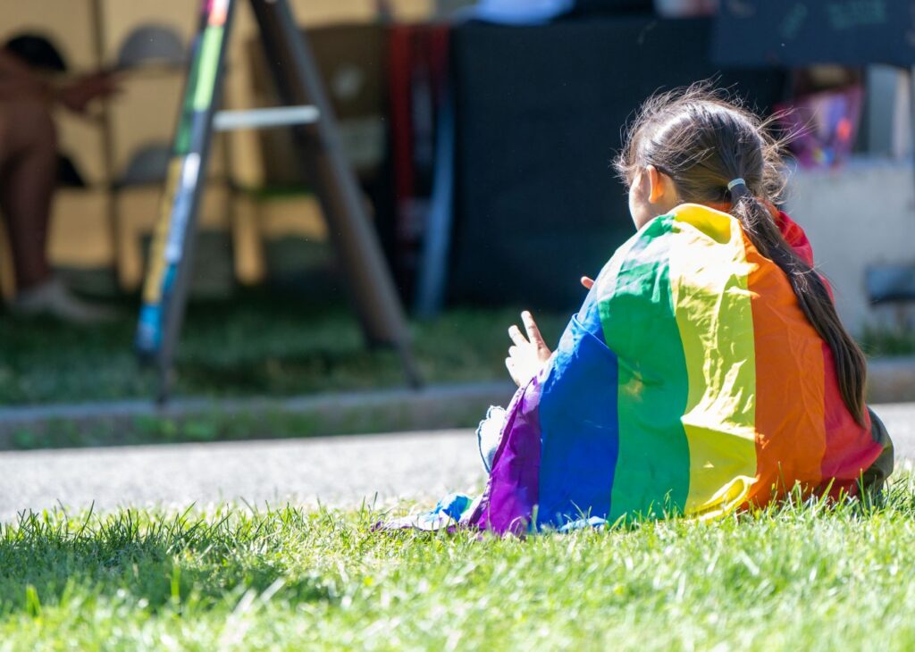 child wrapped in gay pride flag